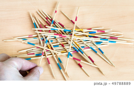 player picks up a stick from pile in Mikado game player picks up a stick from pile in Mikado game 49788889