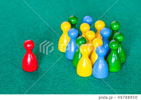 one red pawn in front of many various pawns 49788950