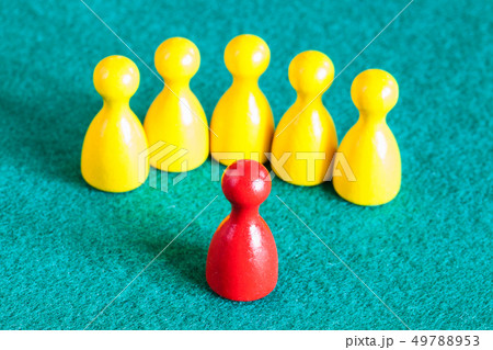 one red pawn in front of several yellow pawns 49788953