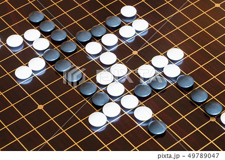 playing stones on wooden board in Go playing stones on wooden board in Go 49789047