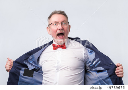 Senior man in suit and glasses looking at camera and laughing on funny joke. 49789676