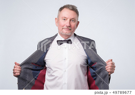 Senior man in suit and glasses looking at camera and laughing on funny joke. 49789677