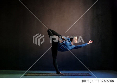 Woman practicing yoga, stretching in Natarajasana exercise 49789760