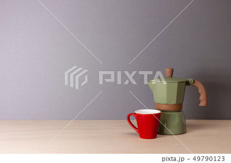 italian coffee maker and small cup on grey background italian coffee maker and small cup on grey background 49790123