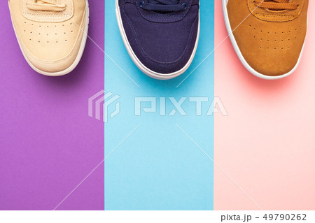 Three pair of sneakers on colored background Three pair of sneakers on colored background 49790262