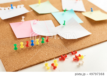 Cork board with a pinned colored blank notes Cork board with a pinned colored blank notes 49797368