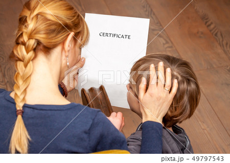 Mother comforting son despite the bad school certificate Mother comforting son despite the bad school certificate 49797543