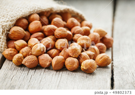 Chiselled hazelnuts in a bag of burlap on a gray 49802373