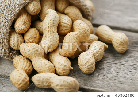 Peanuts in a miniature burlap bag on old, gray 49802480