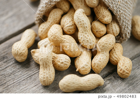 Peanuts in a miniature burlap bag on old, gray 49802483