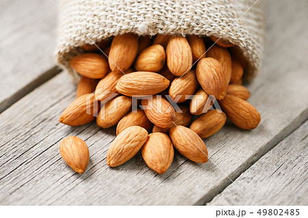 Almond nuts in a burlap bag on a wooden gray Almond nuts in a burlap bag on a wooden gray 49802485