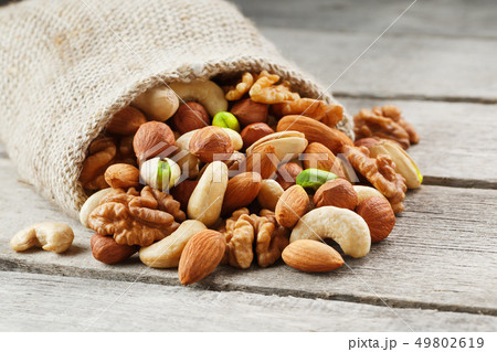 Mix of different nuts in a wooden cup against the Mix of different nuts in a wooden cup against the 49802619