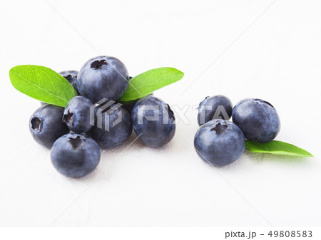 Fresh raw organic blueberries with leaf on white Fresh raw organic blueberries with leaf on white 49808583
