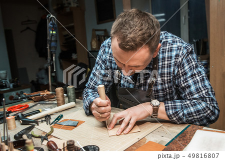 Concept of handmade craft production of leather goods. Concept of handmade craft production of leather goods. 49816807