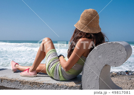 girl on a bench looking at the sea 49817081