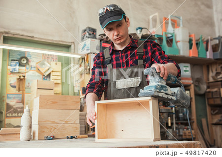 Worker grinds the wood box Worker grinds the wood box 49817420