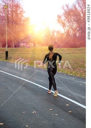 young girl in a black suit runs down the road young girl in a black suit runs down the road 49818824