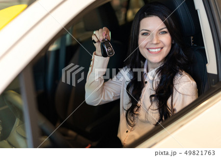 Happy customer woman buying a new car in dealeship center 49821763