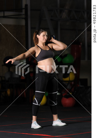 Pregnant female athlete doing hang kettlebell clean and press Pregnant female athlete doing hang kettlebell clean and press 49821783