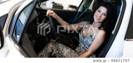 Charming customer brunet sitting in her new car just purchased in dealeship center Charming customer brunet sitting in her new car just purchased in dealeship center 49821797