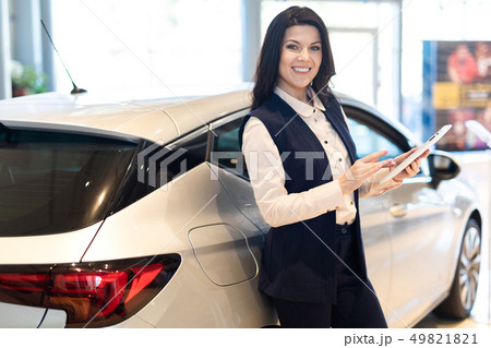 Professional salesperson present a new car in dealership center Professional salesperson present a new car in dealership center 49821821