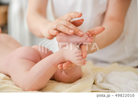 Young woman massage gently baby toes, close up 49822010