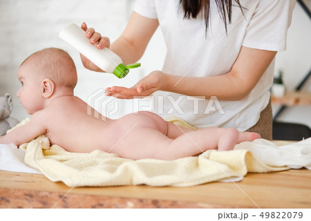 Mother put oil lotion at baby skin Mother put oil lotion at baby skin 49822079