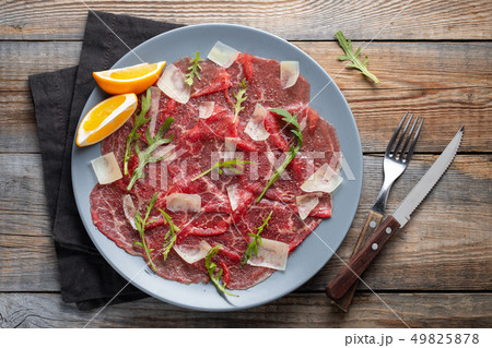 Marbled beef carpaccio with arugula and parmesan. 49825878