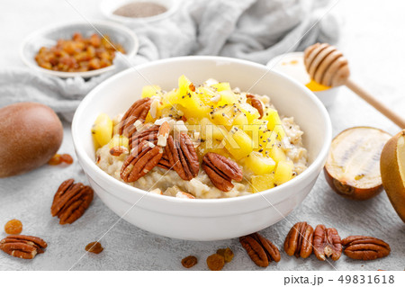 Oatmeal porridge with kiwi fruit, pecan nuts and Oatmeal porridge with kiwi fruit, pecan nuts and 49831618