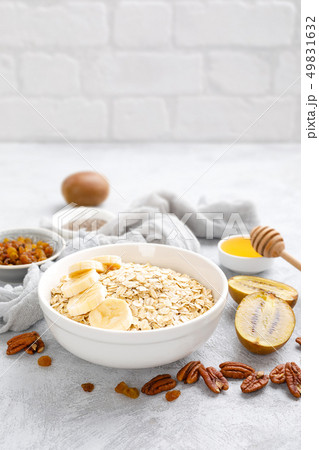 Oat flakes with fruits, nuts and honey in bowl 49831632