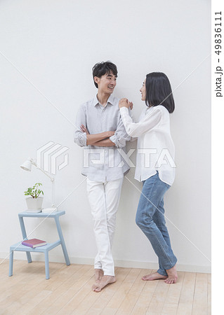 壁際で談笑するカップル 49836111