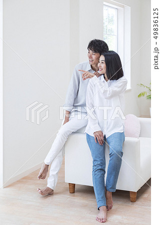 ソファに腰かけるカップルの写真素材