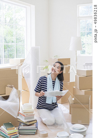 座ってお皿を包む笑顔の女性 座ってお皿を包む笑顔の女性 49836218