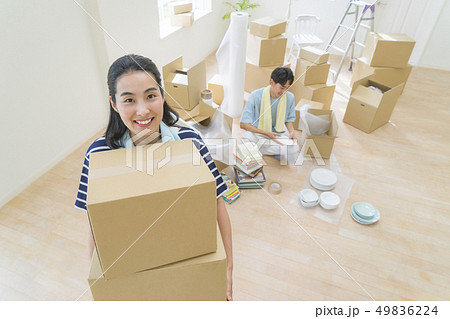 段ボールを持った笑顔の女性と食器を包む男性 49836224