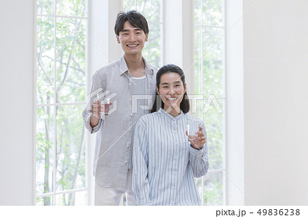 水の入ったコップを持つ笑顔のカップル 水の入ったコップを持つ笑顔のカップル 49836238