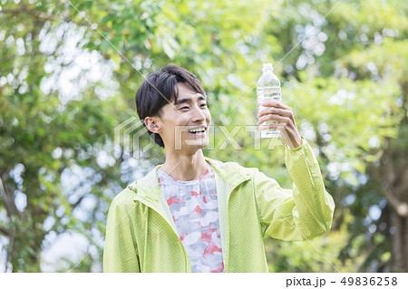 ペットボトルを持って見つめる男性 49836258