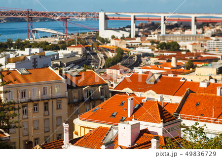 many bright tiled roofs of Lisbon, 25 th April Bridge connecting to of Almada many bright tiled roofs of Lisbon, 25 th April Bridge connecting to of Almada 49836729