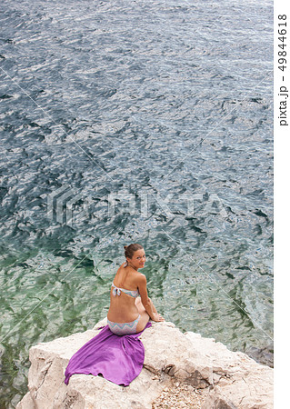 Attractive girl relaxing on a beautiful rocky sea beach. Attractive girl relaxing on a beautiful rocky sea beach. 49844618
