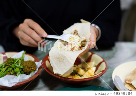 Woman having Arabic food in a restaurant Woman having Arabic food in a restaurant 49849584