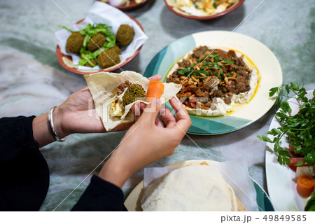 Woman having Arabic food in a restaurant Woman having Arabic food in a restaurant 49849585