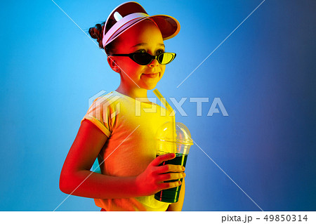 The happy teen girl standing and smiling against blue background. 49850314