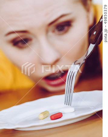 Shocked woman having pills on plate Shocked woman having pills on plate 49850379