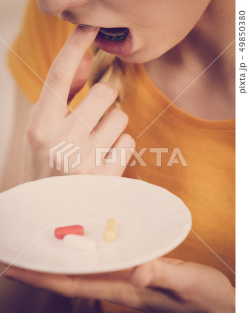 Shocked woman having pills on plate 49850380
