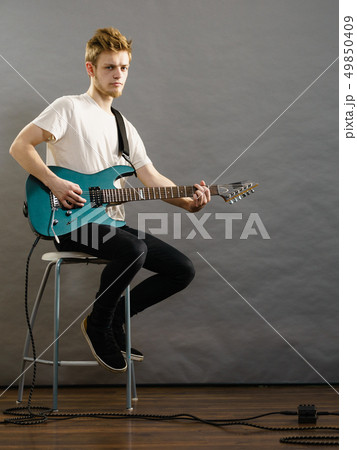 Young man playing electric guitar Young man playing electric guitar 49850409