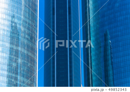 Modern glass skyscrapers against the blue sky in the afternoon Modern glass skyscrapers against the blue sky in the afternoon 49852343