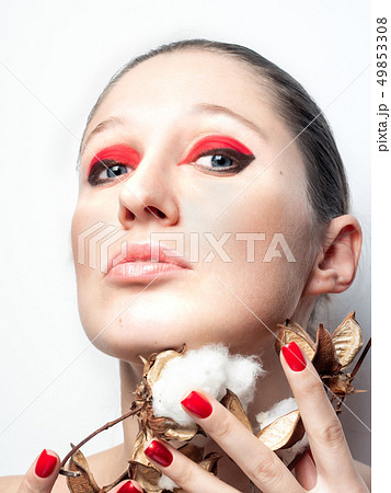 Girl with bright pink makeup and red lips holding natural cotton flower cotton Girl with bright pink makeup and red lips holding natural cotton flower cotton 49853308
