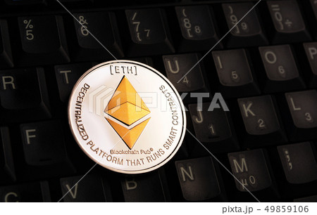 Golden Ethereum ETH coin over black keyboard 49859106