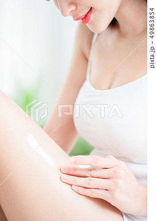 woman applying cream on legs woman applying cream on legs 49863854