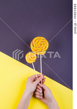Two lollypops on a stick in hand. 49865888