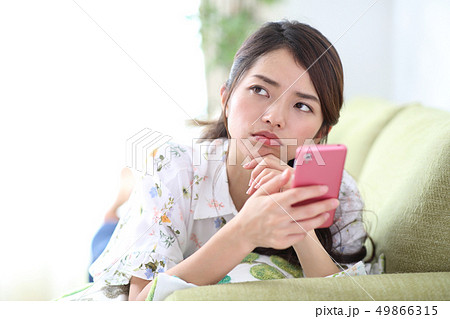 スマホを持って困った顔の女性 スマホを持って困った顔の女性 49866315